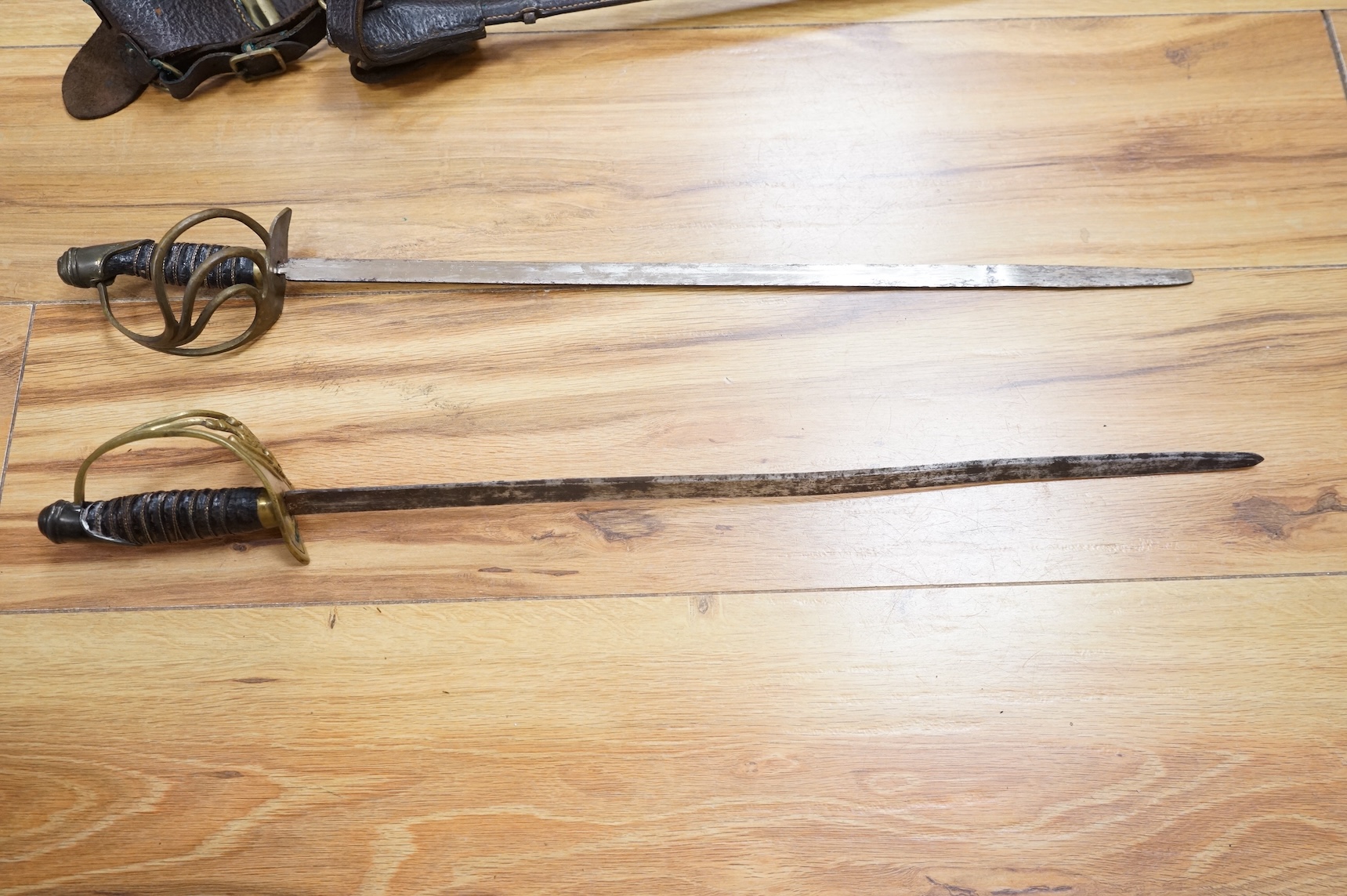 Two early 20th century Imperial German child’s swords with leather scabbards and hangers, blades 45.5cm